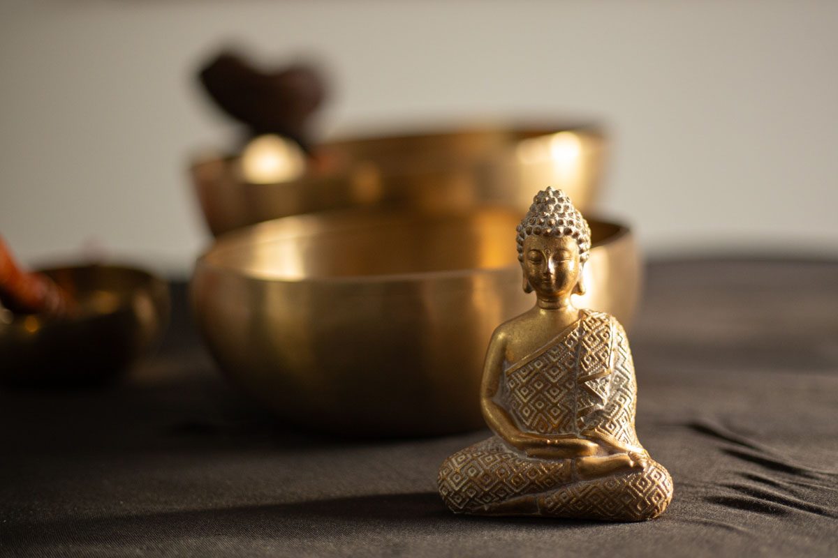 a small statue of a buddha sitting on a table